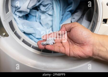 Hand holding lint removed from laundry dryer filter Stock Photo
