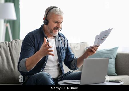 Furious senior businessman having video call with assistant Stock Photo
