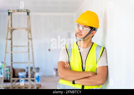Asian engineer or architecture and construction business concept - businessman or architect in helmet at the construction site, building Stock Photo