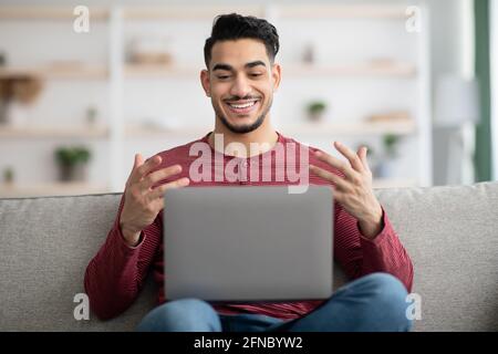Positive arab guy having video chat with girlfriend Stock Photo