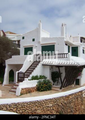 Menorca, Spain - June 23 2006: Typical Spanish whitewashed beach houses based on Cycladic architecture on Menorca. With exterior stairs. Stock Photo