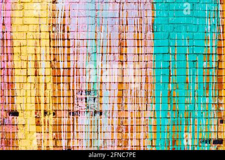 Brick wall with multi-colored drips of paint. Stock Photo