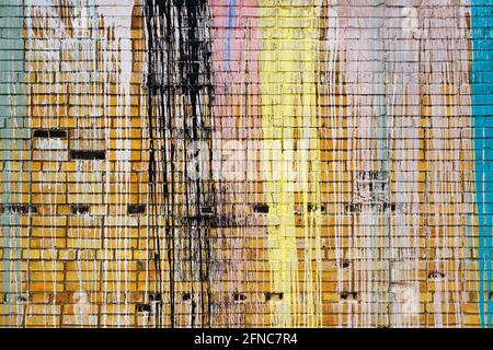 Brick wall with multi-colored drips of paint. Stock Photo