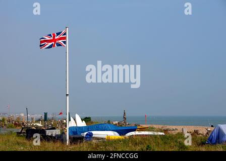 Union flag flying proudly in the breeze, Pevensey Bay beach, East Sussex, England Stock Photo