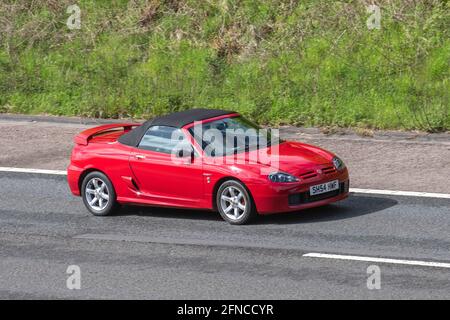 2004 red Mg Tf red 1588 cc roadster; Vehicular traffic, moving vehicles, sports cars, vehicle driving on UK roads, motors, motoring on the M6 motorway highway UK road network. Stock Photo