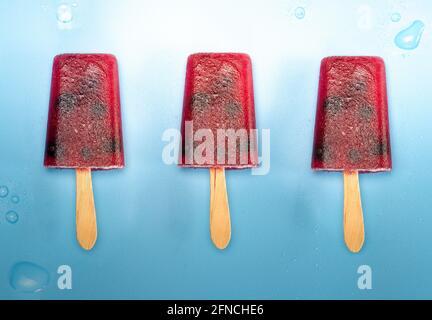 Homemade blueberry ice cream or popsicles on blue background with water drops frozen fruit juice, retro style, top view summer,ice cream,food concept Stock Photo
