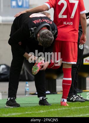 Duesseldorf, Germany. 16th May, 2021. Football: 2. Bundesliga, Fortuna Düsseldorf - Erzgebirge Aue, 33. matchday at Merkus Spiel-Arena: A coach tightens the studs on the shoes of Düsseldorf's midfielder Felix Klaus. Credit: Bernd Thissen/dpa - IMPORTANT NOTE: In accordance with the regulations of the DFL Deutsche Fußball Liga and/or the DFB Deutscher Fußball-Bund, it is prohibited to use or have used photographs taken in the stadium and/or of the match in the form of sequence pictures and/or video-like photo series./dpa/Alamy Live News Stock Photo