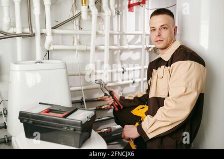 Young repairman holding handtool during work in lavatory Stock Photo