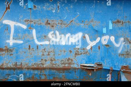 white I love you sign spray painted on blue dumpster exterior Stock Photo