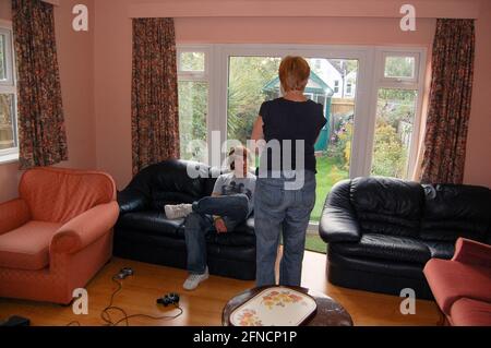 Student relaxing in a shared living room with sofas gaming equipment and a view into the garden capturing everyday student life interiors Stock Photo