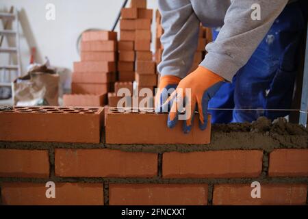 Construction worker building a brick wall. Man bricklaying. Mason laying bricks. Stock Photo