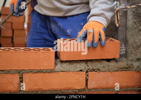 Construction worker building a brick wall. Man bricklaying. Mason laying bricks. Stock Photo