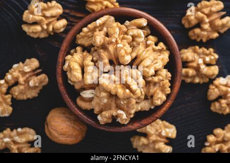 Walnuts in a bowl on black stone background, top view, selective focus Stock Photo