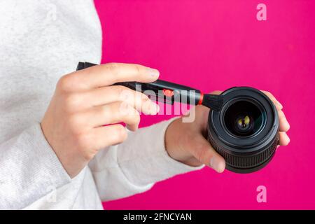 Photo lens cleaning process. The photographer is cleaning his lens. Stock Photo