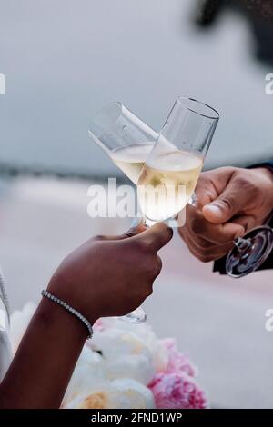 Two hands with glasses making a toast Stock Photo - Alamy
