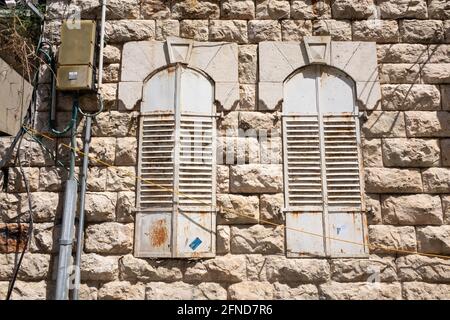 Detail of the windows close with metal shutters of an old building at Nachlaot neighborhood in Jerusalem. Stock Photo