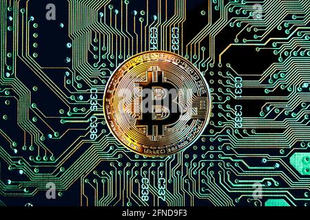 Bitcoin cryptocurrency token coin against circuit board background Stock Photo