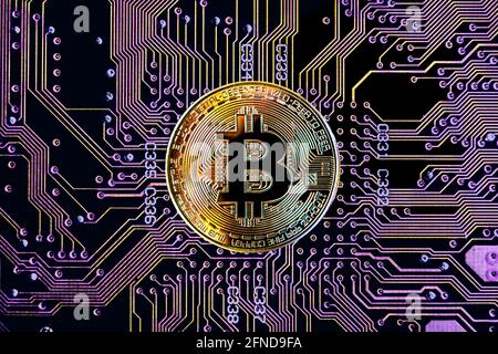 Bitcoin cryptocurrency token coin against circuit board background Stock Photo