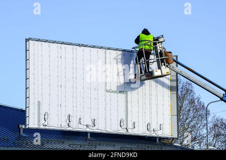 installation of a new large modern billboard with LED lighting on a background of blue sky Stock Photo