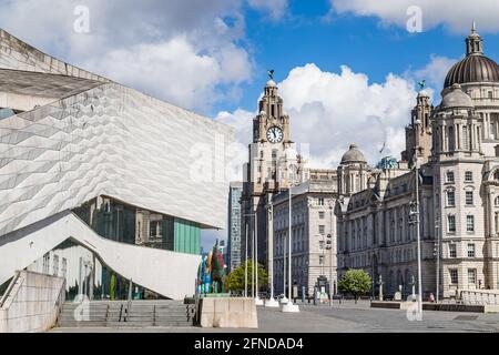 The Museum of Liverpool on the famous Liverpool waterfront pictured in May 2021 next to the Three Graces under a bright sky. Stock Photo