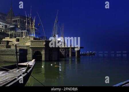 Night wide angle view of ghat located next to ganga river with temple and boats in Varanasi, India in a state of Uttar pradesh. Stock Photo