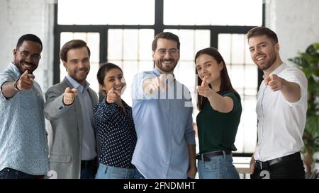 We need you. Happy confident professional group pointing at camera Stock Photo