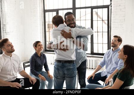 Diverse support community friends hugging on therapy meeting Stock Photo