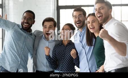 Multiethnic team of excited employees celebrating corporate achievement Stock Photo