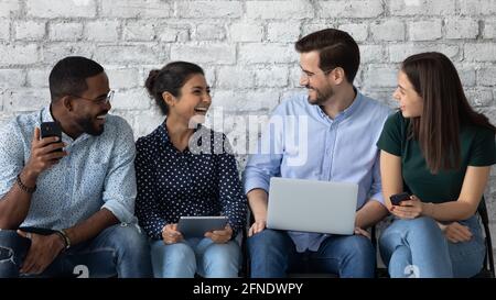 Happy diverse job candidates chatting and laughing while waiting Stock Photo