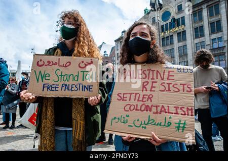 Amsterdam, Netherlands. 16th May, 2021. Protesters seen holding placards against Israel occupation during the demonstration.The Netherlands and thousands of Dutch people gathered at the Dam Square in Amsterdam to condemn the Israeli attacks and the forced evictions of Palestinians from Sheikh Jarrah neighborhood in occupied East Jerusalem. Credit: SOPA Images Limited/Alamy Live News Stock Photo