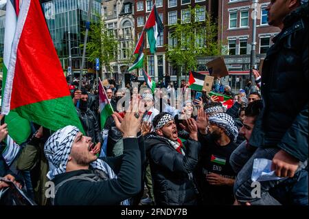Amsterdam, Netherlands. 16th May, 2021. A group of Palestinian men seen shouting Palestinian slogans during the demonstration.The Netherlands and thousands of Dutch people gathered at the Dam Square in Amsterdam to condemn the Israeli attacks and the forced evictions of Palestinians from Sheikh Jarrah neighborhood in occupied East Jerusalem. Credit: SOPA Images Limited/Alamy Live News Stock Photo