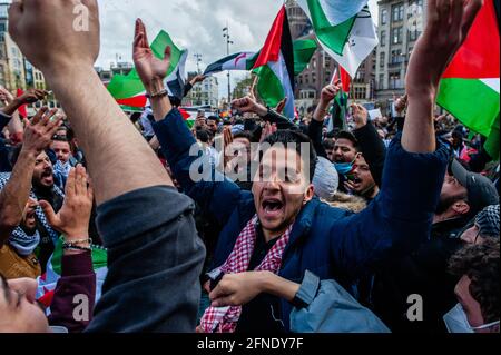 Amsterdam, Netherlands. 16th May, 2021. A Palestinian man seen jumping in the middle of the audience during the demonstration.The Netherlands and thousands of Dutch people gathered at the Dam Square in Amsterdam to condemn the Israeli attacks and the forced evictions of Palestinians from Sheikh Jarrah neighborhood in occupied East Jerusalem. Credit: SOPA Images Limited/Alamy Live News Stock Photo