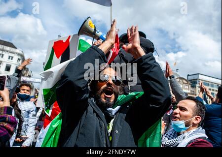 Amsterdam, Netherlands. 16th May, 2021. A protester seen shouting slogans while clapping during the demonstration.The Netherlands and thousands of Dutch people gathered at the Dam Square in Amsterdam to condemn the Israeli attacks and the forced evictions of Palestinians from Sheikh Jarrah neighborhood in occupied East Jerusalem. Credit: SOPA Images Limited/Alamy Live News Stock Photo