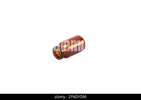 Lying glass vial of brown on white isolated background. Stock Photo