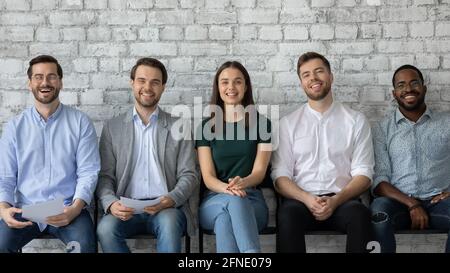 Confident diverse vacancy applicants sitting in queue Stock Photo