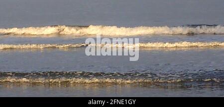 Sunlit small surf Stock Photo