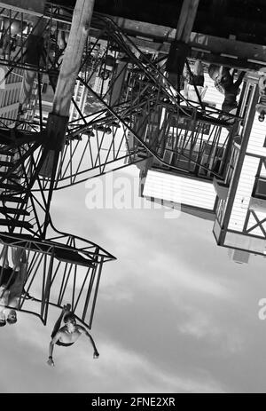 A young man jumps off the Taranaki St dive platform on the Wellington (NZ) waterfront - image turned 180 degrees. Stock Photo