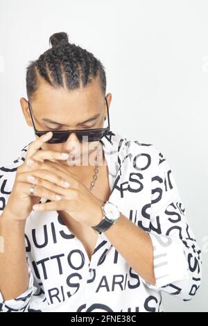 Portrait of a thoughtful Indian male in a fashionable shirt and sunglasses Stock Photo