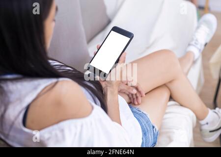 Close up hands of woman using mobile phone, cell phone in coffee shop. Hands of women holding blank empty screen smart phone in cafe. Women relax with Stock Photo