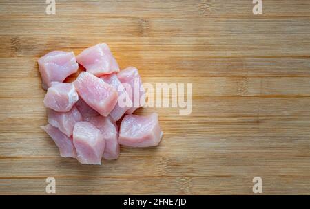 Close up fresh cube Pork Sirloin on wooden cutting board, top view image with blank space for copy and design. Stock Photo