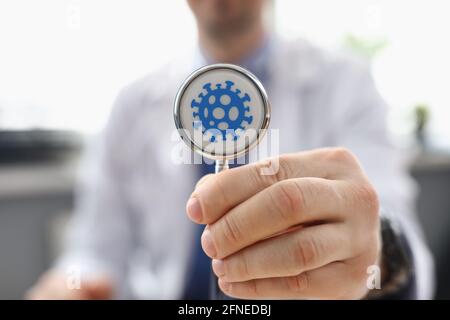 Doctor holds stethoscope with picture of bacteria Stock Photo