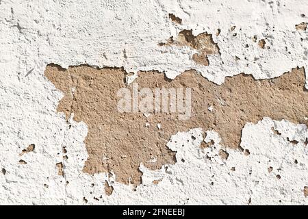 Old grunge background with white peeling plaster on stone wall Stock Photo