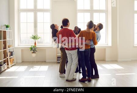 Team of happy diverse people huddling, laughing and having fun in a modern office Stock Photo