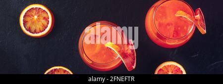 Orange cocktails panorama with blood oranges, top shot on black Stock Photo