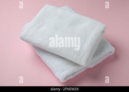 Clean folded towels on pink background, close up Stock Photo