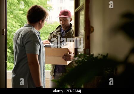 Man digitally signing a tablet for a courier delivery Stock Photo