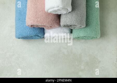 Clean rolled towels on textured background, space for text Stock Photo