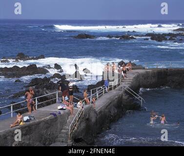 Tourists sunbathe on a pier bordering a sea swimming pool. [automated translation] Stock Photo