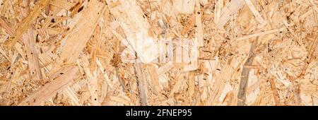 abstract textured background of compressed plywood. texture of light brown pressed wooden board chipboard. top view, close up. banner Stock Photo