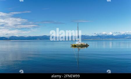 Motueka seafront, a moored trimaran, the Motueka sandspit in the background, Tasman region, New Zealand. Stock Photo